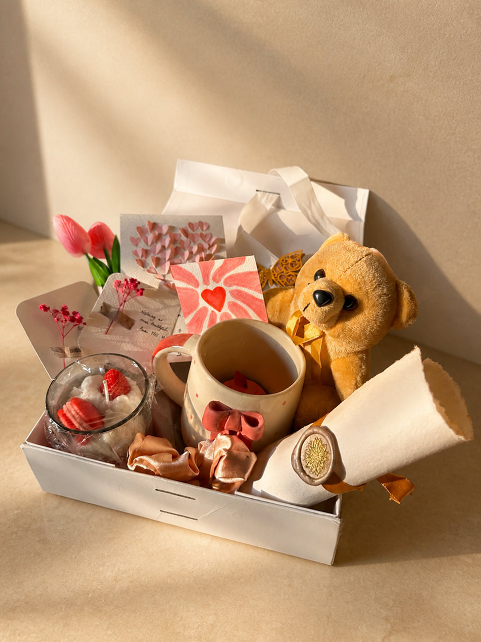 A pink Valentine hamper in a white box, in low sun